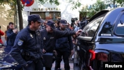 Agentes de policía se disponen a cargar maletines en su vehículo frente a la oficina del expresidente del Gobierno español José Luis Rodríguez Zapatero, el 19 de mayo de 2026. REUTERS/Violeta Santos Moura