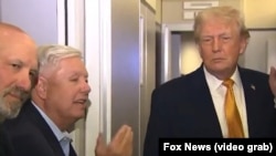 El senador Lindsey Graham (centro) junto al presidente Donald Trump, a bordo del Air Force One.