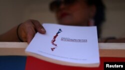 Un ciudadano entrega copias de la nueva constitución chilena propuesta antes del próximo referéndum constitucional del 17 de diciembre, frente al palacio de gobierno en Santiago, Chile, el 27 de noviembre de 2023. REUTERS/Ivan Alvarado