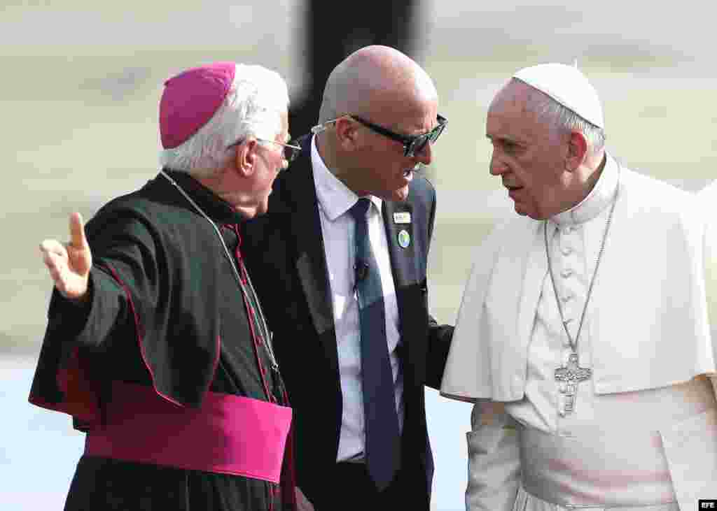 El papa Francisco (d) y el arzobispo Dionisio Guillermo García hablan a su llegada al aeropuerto Antonio Maceo en Santiago de Cuba.
