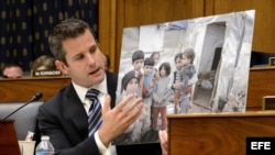 El congresista Republicano por Illinois, Adam Kinzinger, sostiene una fotografía de niños sirios que describe afectados por el gas sarín.