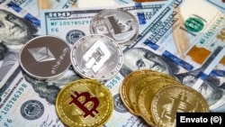 Bitcoin y criptomonedas sobre billetes de cien dólares. (Imagen de referencia)