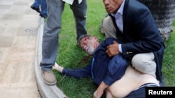 En esta imagen de la agencia Reuters de 2017, el diputado Americo de Grazia es asistido por sus colegas luego de ser golpeado por simpatizantes de Nicolás Maduro.