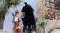 Un miembro de la gendarmería vaticana cubre y detiene a una activista de Femen que intentó llevarse la figura del niño Jesús del belén instalado en la Plaza de San Pedro del Vaticano.