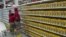 Trabajadores de un supermercado perteneciente a la red pública de alimentación del Gobierno reponen los productos en una estantería.