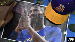 Gorra de Los Ángeles Lakers y foto de Kobe Bryant colocados en memorial al baloncetista