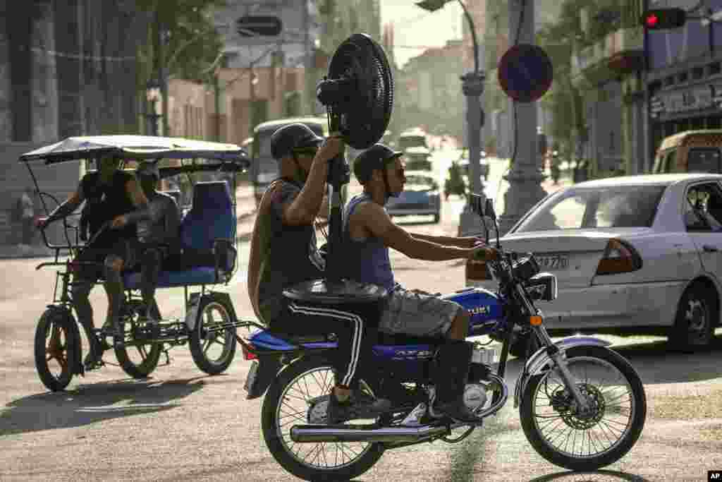 Cubanos transportan un ventilador en La Habana, Cuba, el jueves 6 de abril de 2023. (Foto AP/Ramón Espinosa)