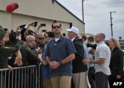 Trump saluda a sus seguidos y firma autógrafos a su llegada a McAllen, Texas.