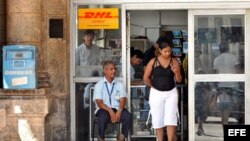 Un empleado estatal custodia la puerta de una oficina de correos en La Habana.