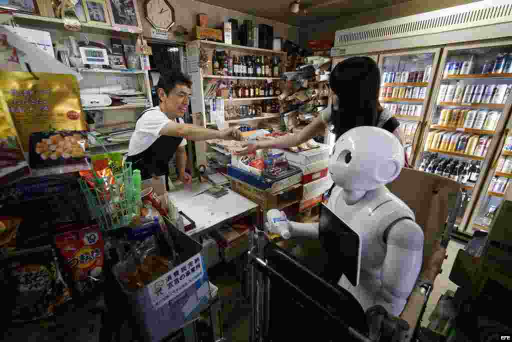 Tomomi Ota (d) hace compras junto a su robot Pepper. 