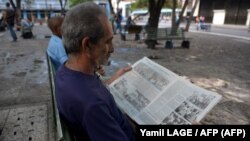 En La Habana un hombre lee el diario oficial Juventud Rebelde. La prensa independiente está proscrita ante la ley, aunque algunos medios son tolerados por el gobierno cubano. Foto: Yamil LAGE / AFP.
