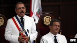El economista Danilo Medina (i), recibe la banda presidencial de manos del gobernante saliente, Leonel Fernández (d), el jueves 16 de agosto de 2012. 