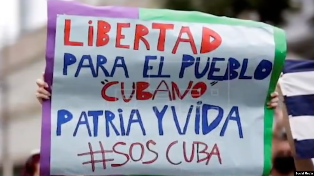 Manifestantes con carteles que piden la libertad de de cuba