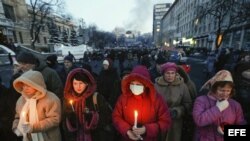 Varias personas sostienen velas durante una ceremonia celebrada en memoria de las personas que murieron en violentos enfrentamientos entre manifestantes y policía, en Kiev (Ucrania) hoy, viernes 24 de enero de 2014