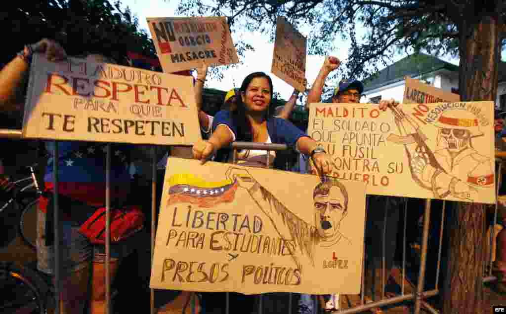  Manifestantes sostienen pancartas hoy, jueves 12 de febrero de 2015, durante una movilización en contra del Gobierno de Nicolás Maduro frente a la Embajada de Venezuela, en Santiago (Chile). En el aniversario de las primeras manifestaciones estudiantiles