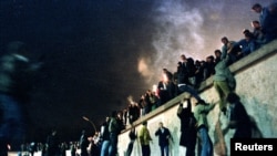 Alemanes escalan el Muro de Berlín en la Puerta de Brandenburg el 9 de noviembre de 1989. (REUTERS/Herbert Knosowski).