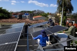 Trabajadores instalan un panel solar en la azotea de un establecimiento comercial privado en La Habana, Cuba, 18 de febrero de 2026. REUTERS/Norlys Perez