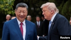El presidente de Estados Unidos, Donald Trump, conversa con el presidente chino, Xi Jinping, mientras se retiran tras una visita al Jardín de Zhongnanhai en Pekín, China, el 15 de mayo de 2026. REUTERS/Evan Vucci/Pool.