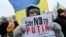 "Diga NO a Putin", pide el cartel que porta una manifestante pacífica en Ucrania el 9 de enero de 2022. (Sergei SUPINSKY/AFP).