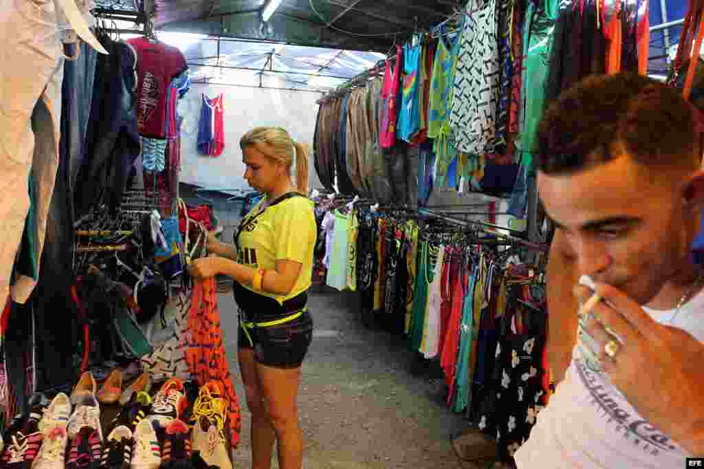 Una mujer organiza la mercancía en un pequeño negocio privado de venta de ropa importada en La Habana (Cuba). 