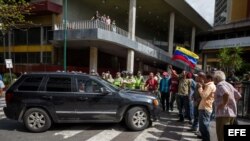 El dirigente opositor venezolano, Carlos Ocariz, permanece dentro de una camioneta mientras personas adeptas al gobierno nacional impiden su paso al Consejo Nacional Electoral (CNE).