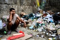 Ciudadano de Caracas esperando la basura para poder comer