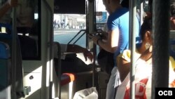 Pagando el costo del pasaje en La Habana en un ómnibus.