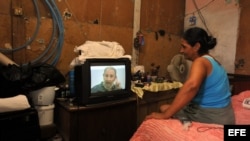 Una mujer sigue la intervención de Fidel Castro en el programa de televisión "Mesa Redonda".