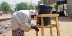 Mujer en Borno, Nigeria, se lava las manos de acuerdo a instrucciones de prevención de COVID-19