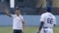 Cristiano Ronaldo (i) sonríe frente a Yasiel Puig (d) tras realizar el lanzamiento previo al inicio del juego de la MLB entre los Dodgers de Los Ángeles y los Yankees de Nueva York en el Dodger Stadium. 