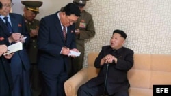 Fotografía cedida por el periódico del gobernante partido norcoreano de los Trabajadores, Rodong Sinmun, que muestra al líder Kim Jong-un (d) apoyado en un bastón durante su visita al distrito residencial científico Wisong, en Pyongyang (Corea del Norte).
