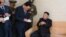 Fotografía cedida por el periódico del gobernante partido norcoreano de los Trabajadores, Rodong Sinmun, que muestra al líder Kim Jong-un (d) apoyado en un bastón durante su visita al distrito residencial científico Wisong, en Pyongyang (Corea del Norte).