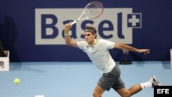 El tenista suizo Roger Federer devuelve la pelota…