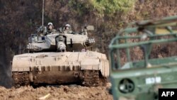 Un tanque de batalla y tropas israelíes están posicionados a lo largo de la frontera con la Franja de Gaza, en el sur de Israel, el 17 de enero de 2024, en medio de las batallas en curso entre Israel y el grupo militante palestino Hamás. (Photo by JACK GUEZ / AFP)