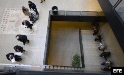 Unas personas hacen cola para votar en un colegio electoral ubicado en una biblioteca pública en Boston.