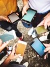 Jóvenes con sus teléfonos celulares en una imagen de referencia