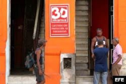 Varios hombres conversan en la puerta de un cine 3D de propiedad privada en La Habana (Cuba).