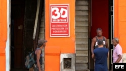 Varios hombres conversan en la puerta de un cine 3D de propiedad privada en La Habana (Cuba).