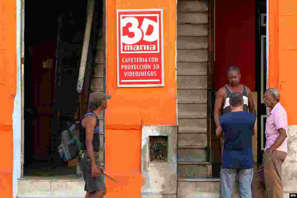 Varios hombres conversan en la puerta de un cine 3D de propiedad privada en La Habana (Cuba).