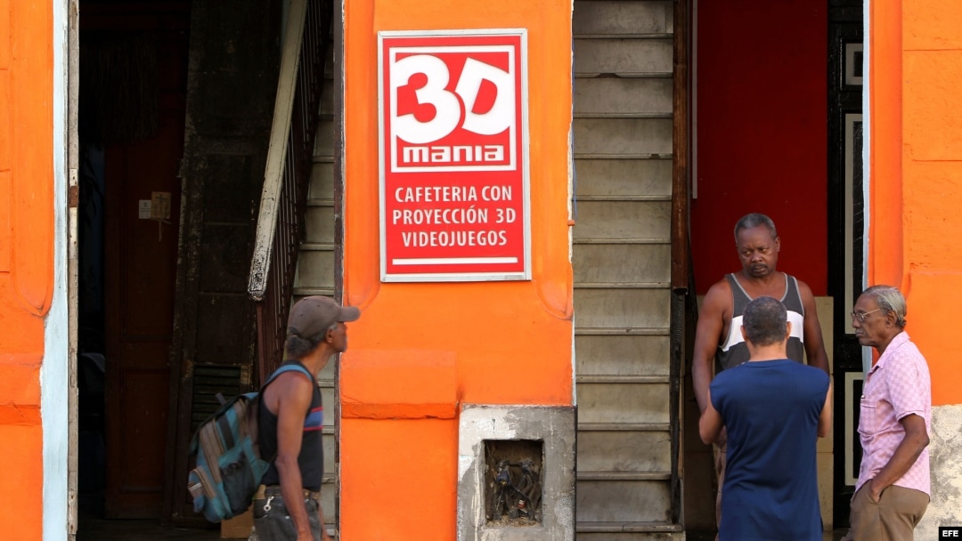 Archivo - Varios hombres conversan en la puerta de un cine 3D de propiedad privada en La Habana (Cuba).