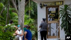 Personas esperan afuera de una oficina de la Western Union en La Habana.