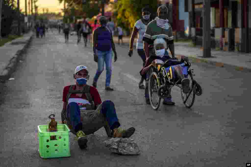 Seguidores de San Lázaro, con máscaras, en medio de la pandemia de coronavirus, rezan durante la peregrinación al santuario del santo para su fiesta anual, en el barrio El Rincón de Santiago de Las Vegas. (AP Photo/Ramon Espinosa)