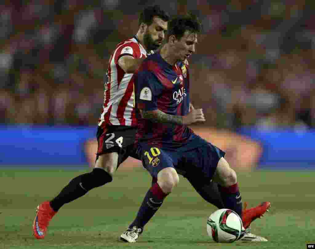 El delantero del FC Barcelona Leo Messi (d) protege el balón ante Balenziaga, del Athletic de Bilbao.