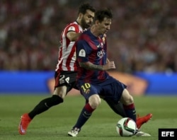 El delantero del FC Barcelona Leo Messi (d) protege el balón ante Balenziaga, del Athletic de Bilbao.