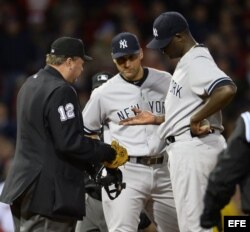 El lanzador de los Yankees de Nueva York Michael Pineda (d) muestra su mano al árbitro Gerry Davis (i), junto al torpedero Derek Jeter (c).