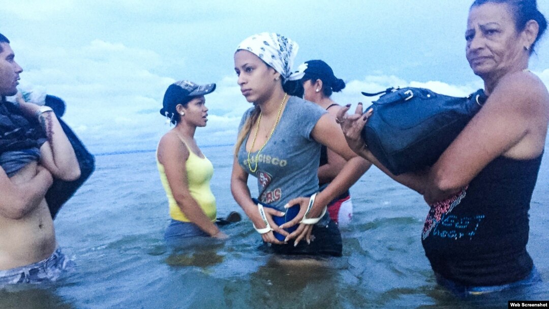 Liset y Marta se preparan para abordar un bote en Colombia mientras se acercan a la frontera con Panamá. (Fotografía de Lisette Poole. Screenshot NPR)
