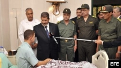 El presidente Mohamed Morsi (2-i) visita a una soldado egipcio que fue herido en un ataque en la región fronteriza de Rafah, en un hospital de El Cairo, Egipto hot, martes 7 de agosto de 2012.