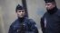 Agentes de policía franceses permanecen en guardia en una calle junto a la sede del semanario satírico francés "Charlie Hebdo".