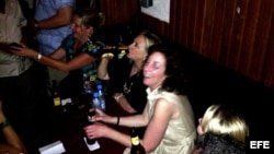 La secretaria de Estado de Estados Unidos, Hillary Clinton (c), tomando cerveza, durante una fiesta en Cartagena (Colombia).