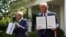 Los presidentes de Estados Unidos y México, Donald Trump y Andrés Manuel López Obrador, muestran sendas copias de la declaración conjunta firmada por ambos minutos antes en los jardines de la Casa Blanca (Kevin Lamarque/Reuters).